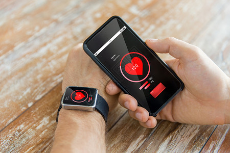 技术,保健,应用人的近距离的男手智能手机,穿着智能手表与红色心脏图标屏幕上测量脉搏背景图片