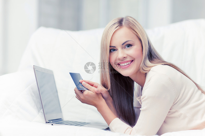 微笑的女商人带着笔记本电脑信用卡带笔记本电脑信用卡的女商人图片