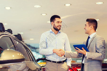 汽车业务,汽车销售,技术,手势人的快乐的人汽车经销商与平板电脑车展沙龙握手图片