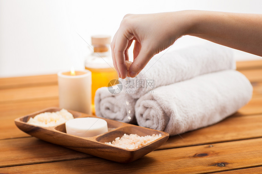 美容,水疗,身体护理天然化妆品密切的手倒喜马拉雅盐木碗与肥皂,擦洗浴巾桌子上图片