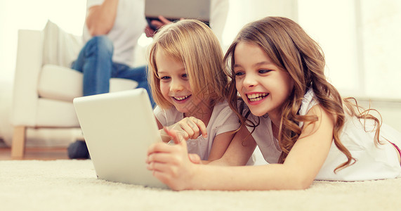 家庭,孩子,技术家庭微笑的妹妹与平板电脑父母背与笔记本电脑图片