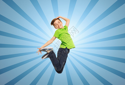 幸福,童,自由,运动人的微笑的男孩蓝色的爆炸背景上跳跃图片