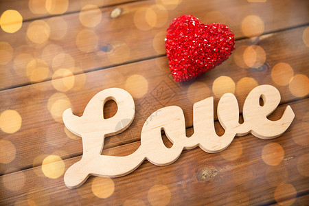 爱情,约会,浪漫,情人节假期的文字爱情与红色的心装饰木材上的金色灯光图片