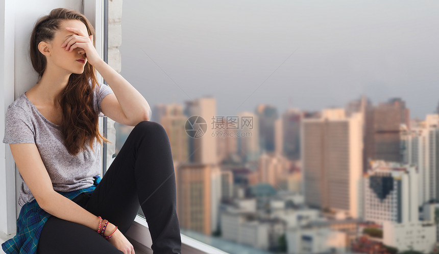 人,情感青少的悲伤快乐的漂亮少女坐窗台上的城市背景图片