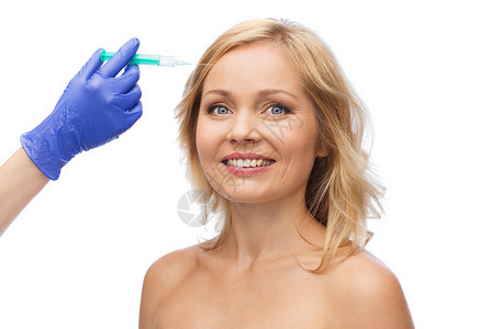 美容,抗衰容手术的微笑的女人脸美容师携手手套与注射器注射额头背景图片