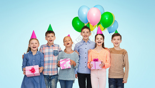 童,假期,友谊人的快乐的微笑孩子戴着派帽,生日礼物气球蓝色背景下图片