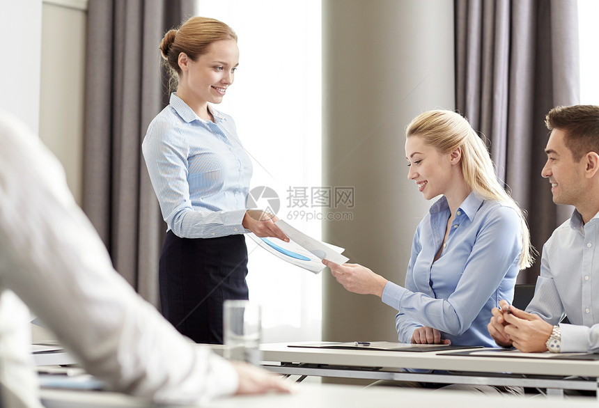 商业,人队合作的微笑的女人给群商人办公室里的文件图片