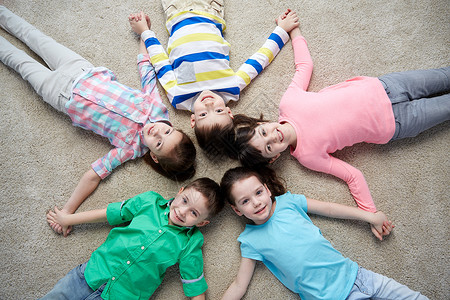 童,时尚,友谊人的群快乐微笑的孩子躺地板上,牵着手图片