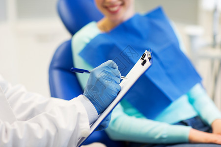 人,医学,口腔科保健牙医与剪贴板快乐的病人妇女牙科诊所办公室图片