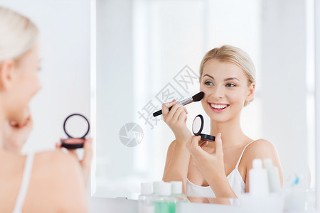 美丽,化妆,化妆品,早晨人的微笑的轻女人用化妆刷涂腮红,家里的浴室照镜子图片