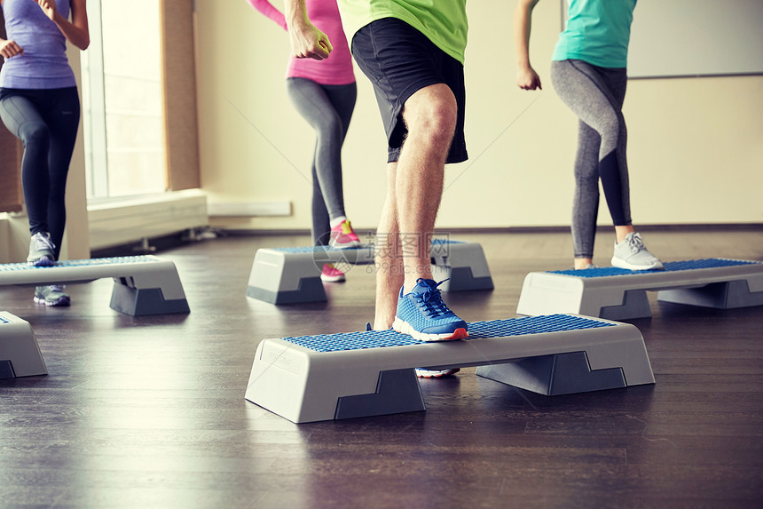 健身,运动,健美操人的群微笑的人健身房的台阶平台上锻炼弯曲腿图片