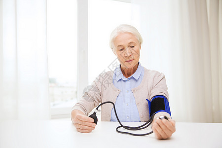 医学,龄,保健人的老妇女用血压计检查血压水平家里控制高清图片素材