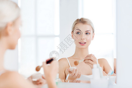 美容,化妆,化妆品,早上人的微笑的轻女人化妆刷粉底家里的浴室镜子图片