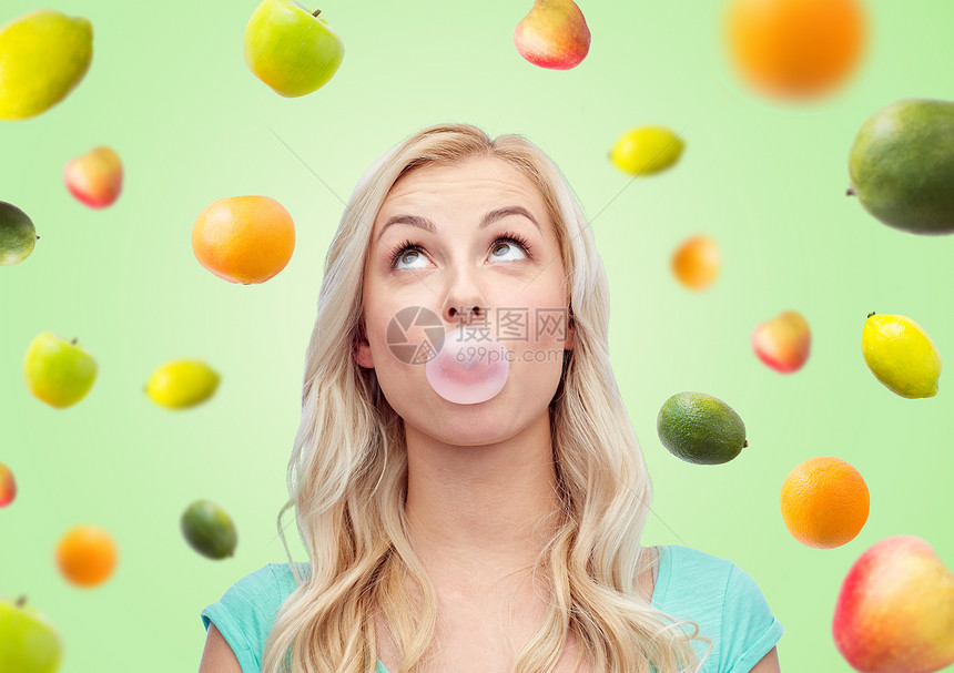 夏天,健康的饮食,情感,表情人的快乐的轻女人十几岁的女孩绿色背景下嚼口香糖水果图片