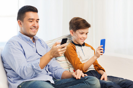 休闲,技术,家庭人的快乐的父子与智能手机短信家玩游戏图片