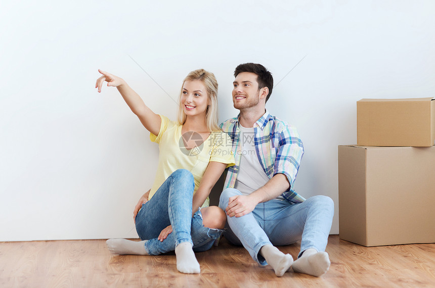 人们,修理房地产的微笑的夫妇与盒子搬新的家梦想图片