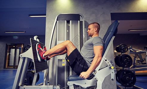 运动,健身,生活方式人的男人锻炼弯曲腿部肌肉健身房机器图片