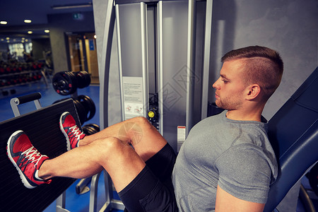 运动,健身,生活方式人的男人锻炼弯曲腿部肌肉健身房机器图片