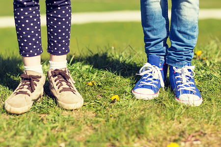 人,孩子,朋友友谊的户外草地上把孩子的腿放鞋子里图片