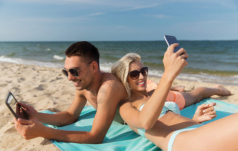 爱情,旅行,旅游,技术人的快乐的夫妇度假与平板电脑智能手机日光浴夏季海滩图片