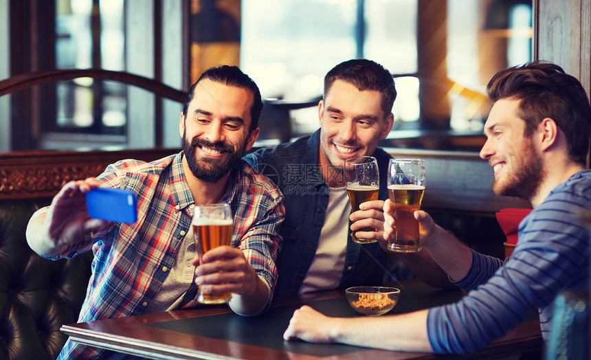 人,男人,休闲,友谊技术快乐的男朋友酒吧酒吧喝啤酒用智能手机自拍图片