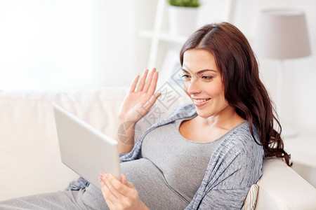 怀孕,母,技术,人期望快乐的孕妇与平板电脑电脑视频呼叫挥手家图片