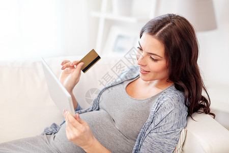 怀孕,网上购物,技术人的快乐孕妇与平板电脑信用卡家图片