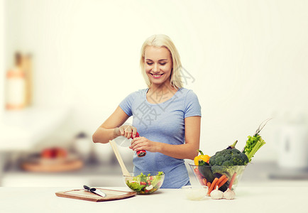 健康饮食,素食,饮食人们的微笑的轻妇女烹饪蔬菜沙拉厨房背景图片