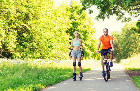 健身,运动,夏天,人们健康的生活方式快乐的夫妇与溜冰鞋自行车骑户外夏天图片