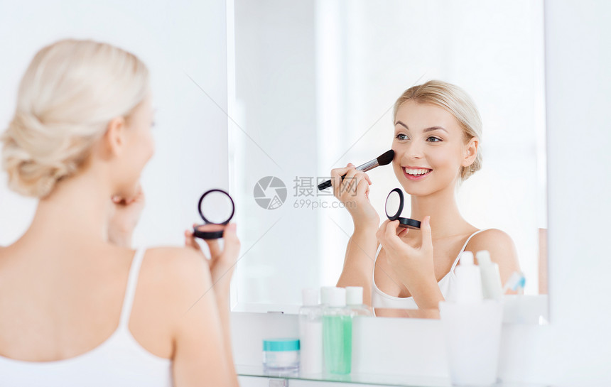美丽,化妆,化妆品,早晨人的微笑的轻女人用化妆刷涂腮红,家里的浴室照镜子图片