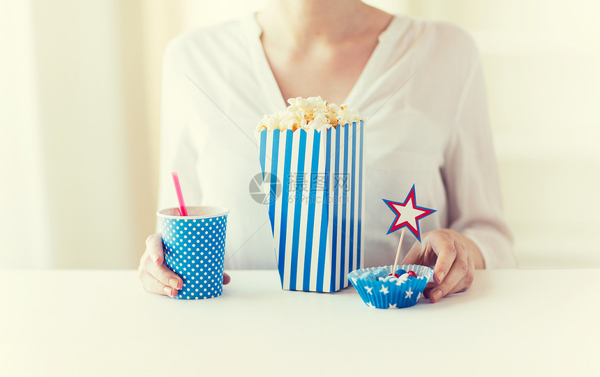 美国独立日,庆祝,主义节日的妇女吃爆米花与饮料糖果7月4日的聚会图片