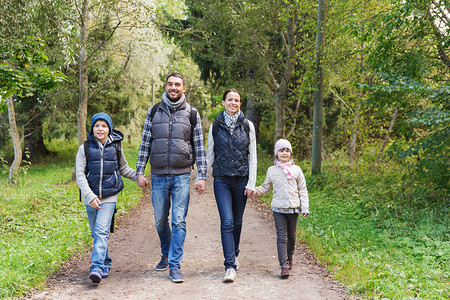 冒险,旅行,旅游,徒步旅行人们的快乐的家庭步行与背包森林图片