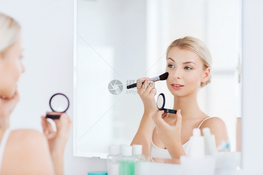 美容,化妆,化妆品,早晨人的轻的女人用化妆刷涂腮红,家里的浴室照镜子图片