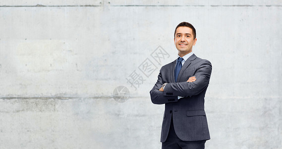 商业,人办公室的快乐的微笑商人穿着深灰色西装灰色混凝土墙背景背景图片
