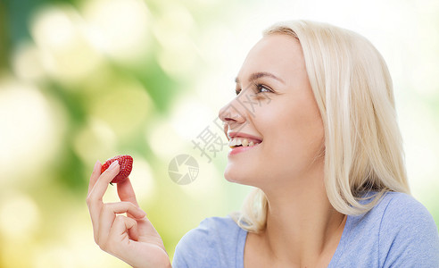 健康的饮食,食物,水果,饮食人们的快乐的女人吃草莓绿色的自然背景图片