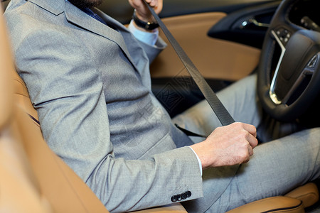 安全驾驶人的贴身穿着优雅的商务套装,系好汽车安全带图片