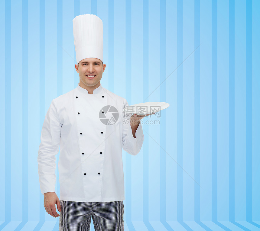 烹饪,职业,广告人的快乐的男厨师蓝色条纹背景的空盘子上展示些东西图片