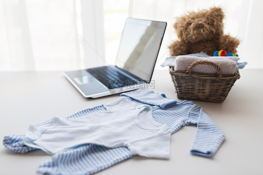 婴儿期,母亲,服装,技术象婴儿衣服玩具的新生儿男孩篮子与笔记本电脑家图片