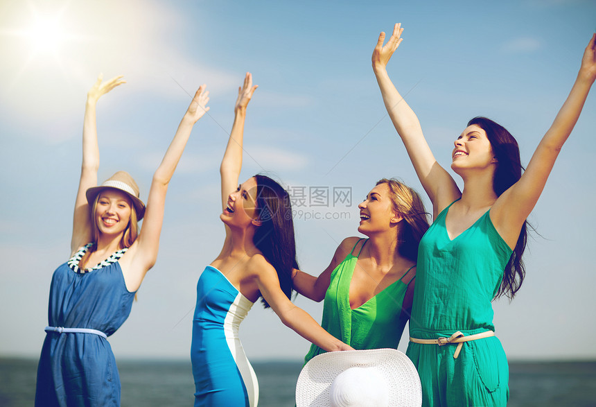 暑假假期女孩们海滩上举手女孩们举手看着大海图片