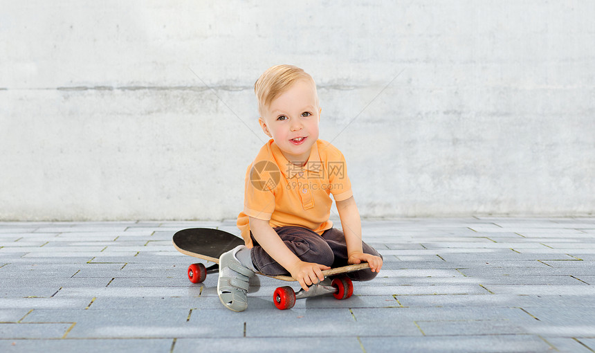 童,运动,休闲人的快乐的小男孩坐滑板上的城市街道背景图片