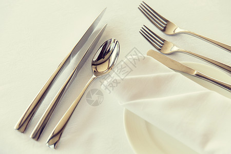 餐桌,银器饮食餐具套装与餐巾纸盘子餐厅的桌子上高清图片