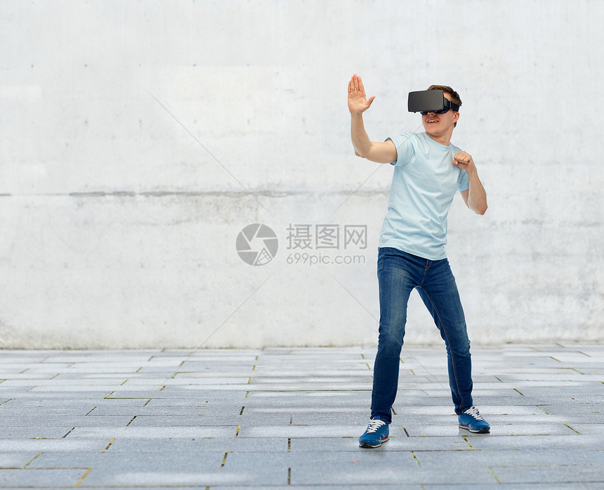 三维技术,虚拟现实,娱乐活动,网络人的轻人与虚拟现实耳机3D眼镜玩游戏战斗的街道背景图片