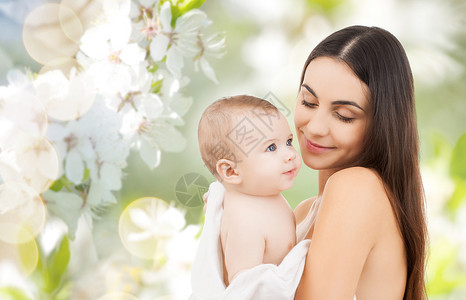 家庭,母亲,养育,人儿童保育的快乐的母亲抱着可爱的婴儿绿色的自然背景图片