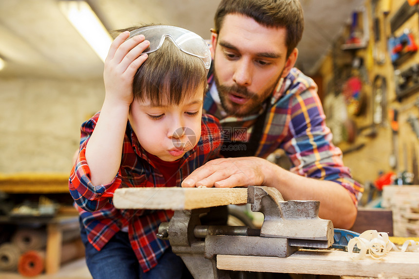 家庭,木工,木工人的父亲小儿子车间用木板工作图片