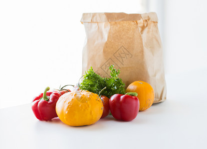 烹饪,饮食,素食健康饮食纸袋与新鲜成熟多汁的蔬菜,绿色水果厨房的桌子上图片