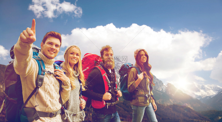 冒险,旅行,旅游,徒步旅行人们的群微笑的朋友带着背包高山天空背景上行走图片