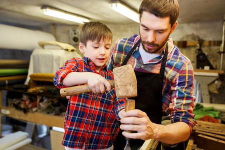 家庭,木工,木工人的父亲小儿子用凿子车间用木板工作高清图片