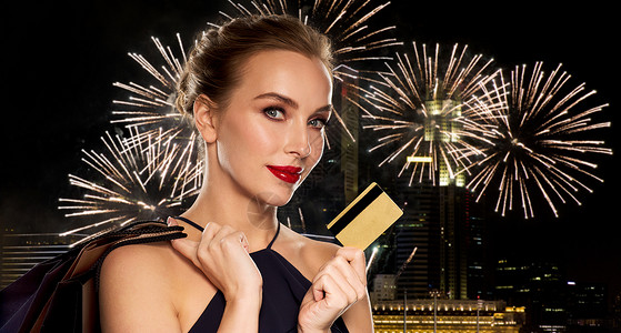 人,豪华销售美丽的女人与信用卡购物袋过夜新加坡城市烟火背景图片