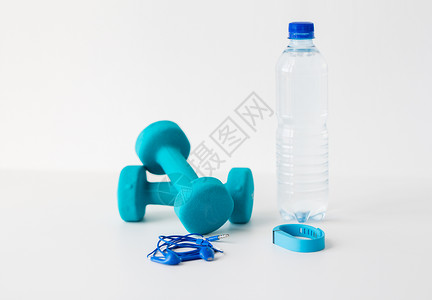 运动,健康的生活方式物品哑铃,健身跟踪器,耳机水瓶白色背景图片