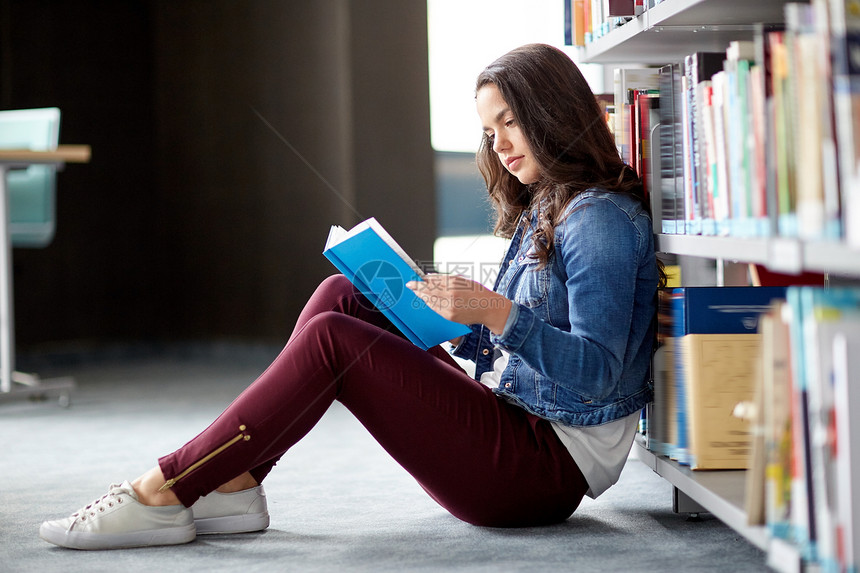 教育,高中,大学,学人的学生女孩阅读书籍坐图书馆的地板上图片